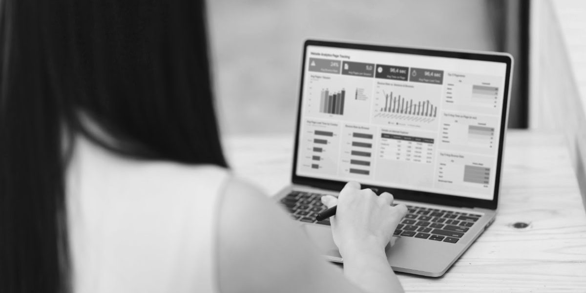 Person Analyzing Data On Laptop, Focusing On Various Charts And Graphs Displayed On Screen. Setting Suggests Modern Workspace, Emphasizing Productivity And Technology