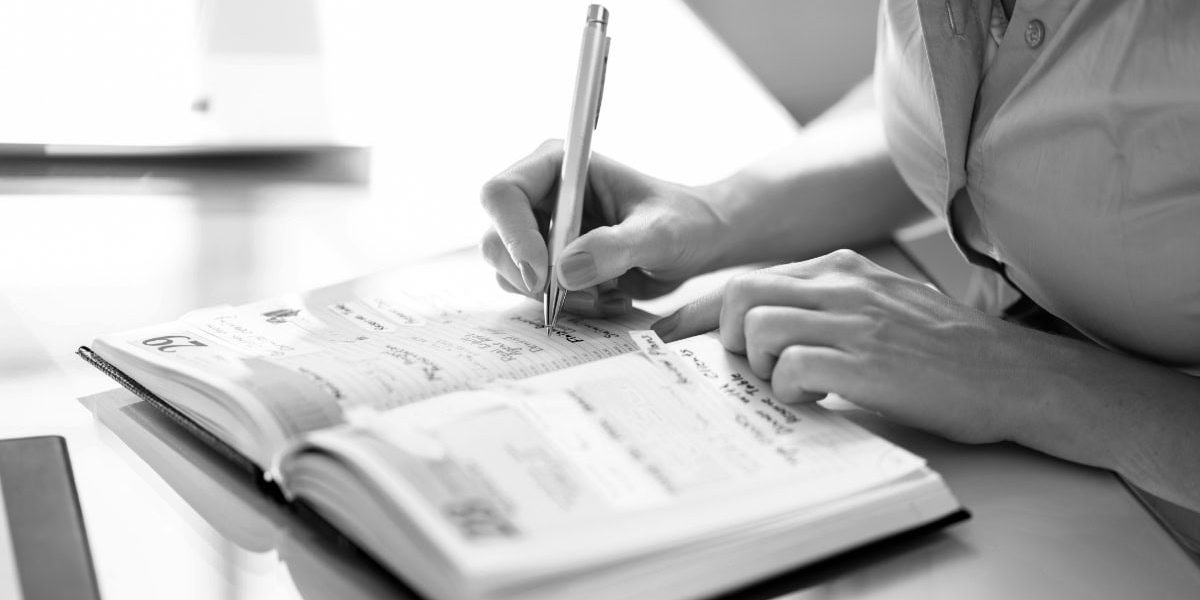 Woman Writing In Calendar